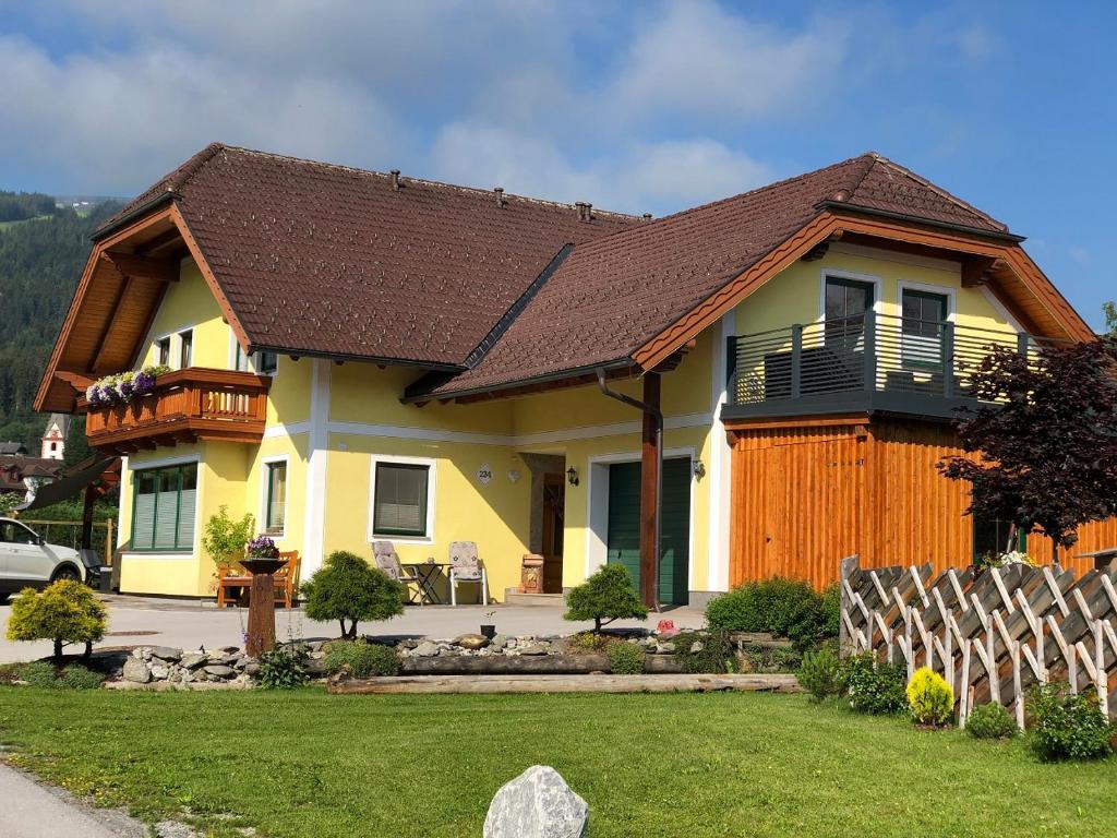 uma casa amarela com um telhado castanho em Ferienwohnungen Wind em Sankt Margarethen im Lungau