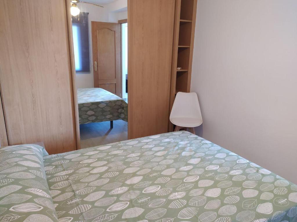 Schlafzimmer mit einem Bett und einem Spiegel in der Unterkunft COSTA DE ALMERIA PLAYA in Almería