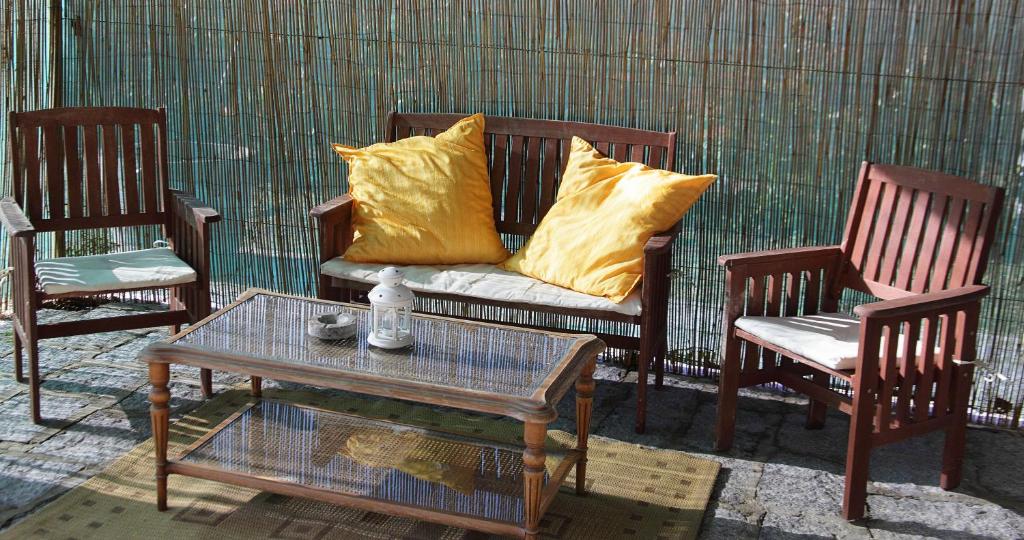 un divano con cuscini gialli, posto tra due sedie di Agriturismo dei girasoli a Portoferraio