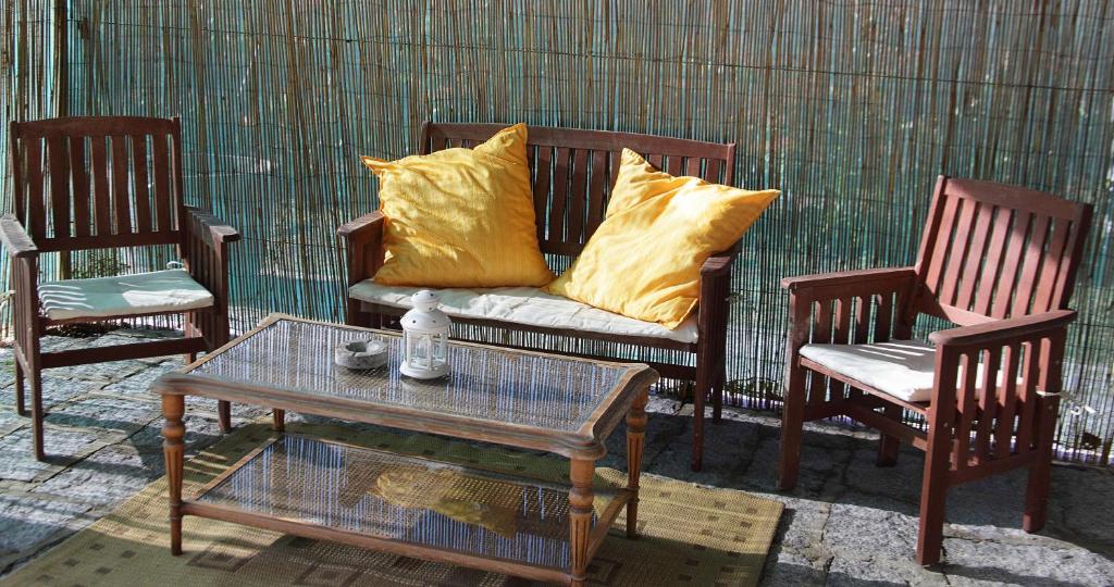 a couch with yellow pillows sitting between two chairs at Agriturismo dei girasoli in Portoferraio