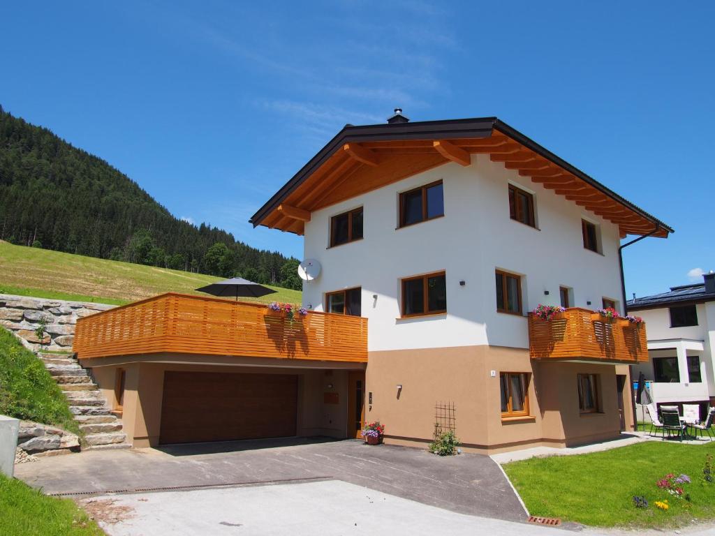 a white house with a brown roof and a garage at Appartment Dutzler in Sankt Martin am Tennengebirge