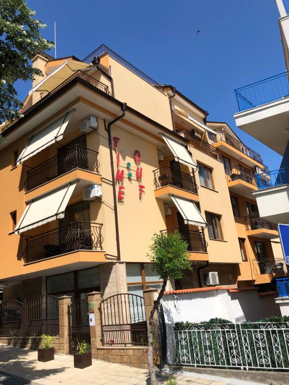 d'un grand bâtiment jaune avec balcon. dans l'établissement Time out, à Sozopol