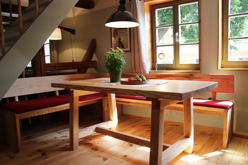 une salle à manger avec une table en bois et des escaliers dans l'établissement Wohlfühl Appartement - Kaisereinsde - traditionelles Lehmhaus Parken gratis, à Quedlinbourg