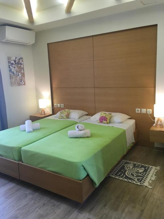 two beds in a bedroom with two towels on them at Georges Estates Hotel in Stoupa