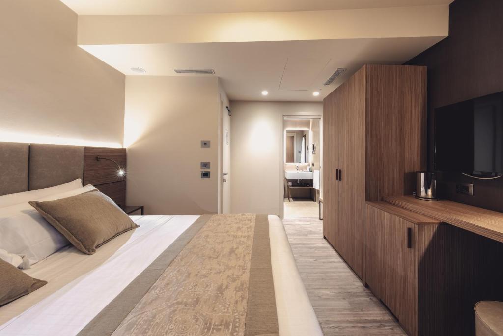 a bedroom with a large bed and a flat screen tv at Hotel Aquarius Venice - Ascend Collection in Venice