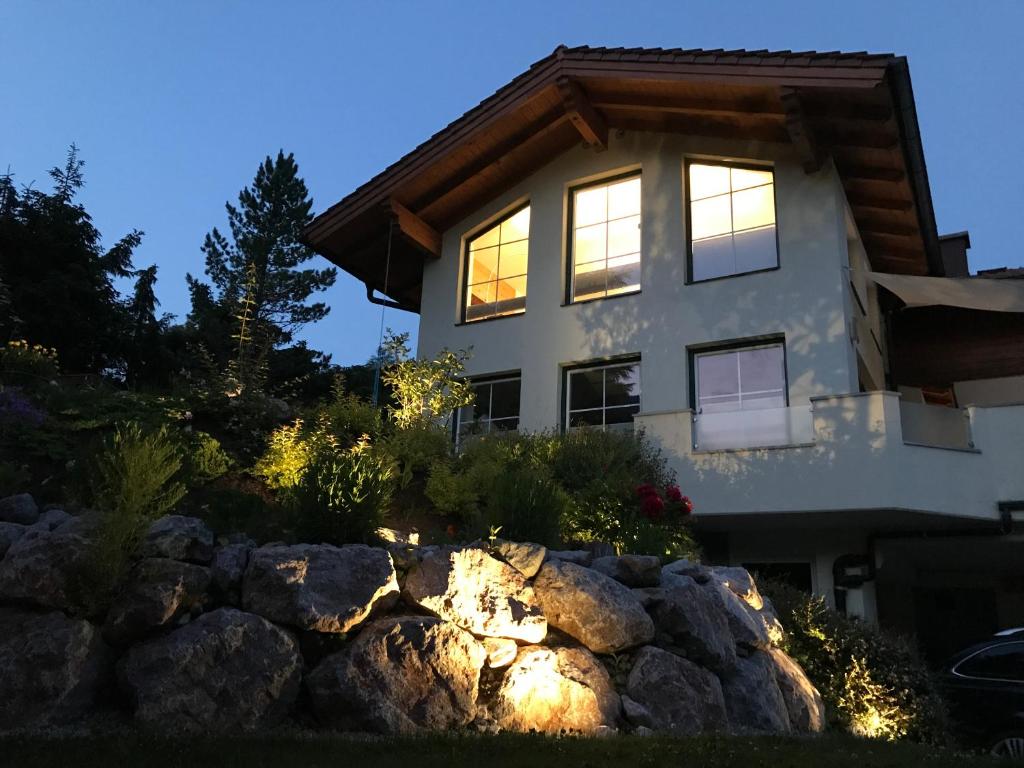 a house with lights in front of a stone wall at Appartementhaus Finis in Ramsau am Dachstein