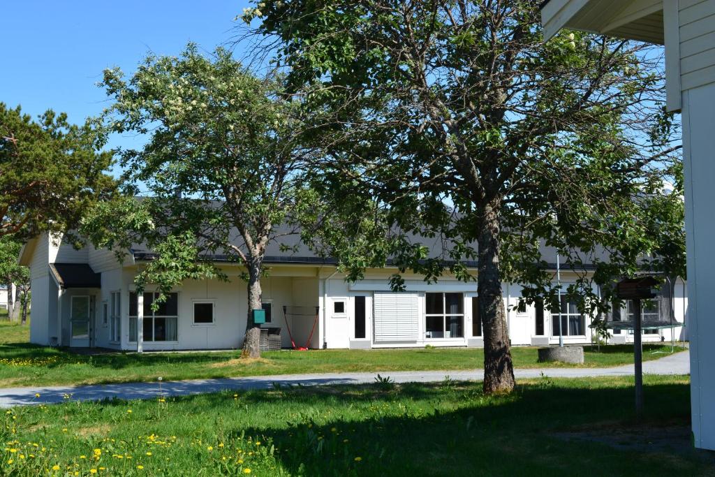 a white building with trees in front of it at Isfjorden Turisthotell & motell in Isfjorden