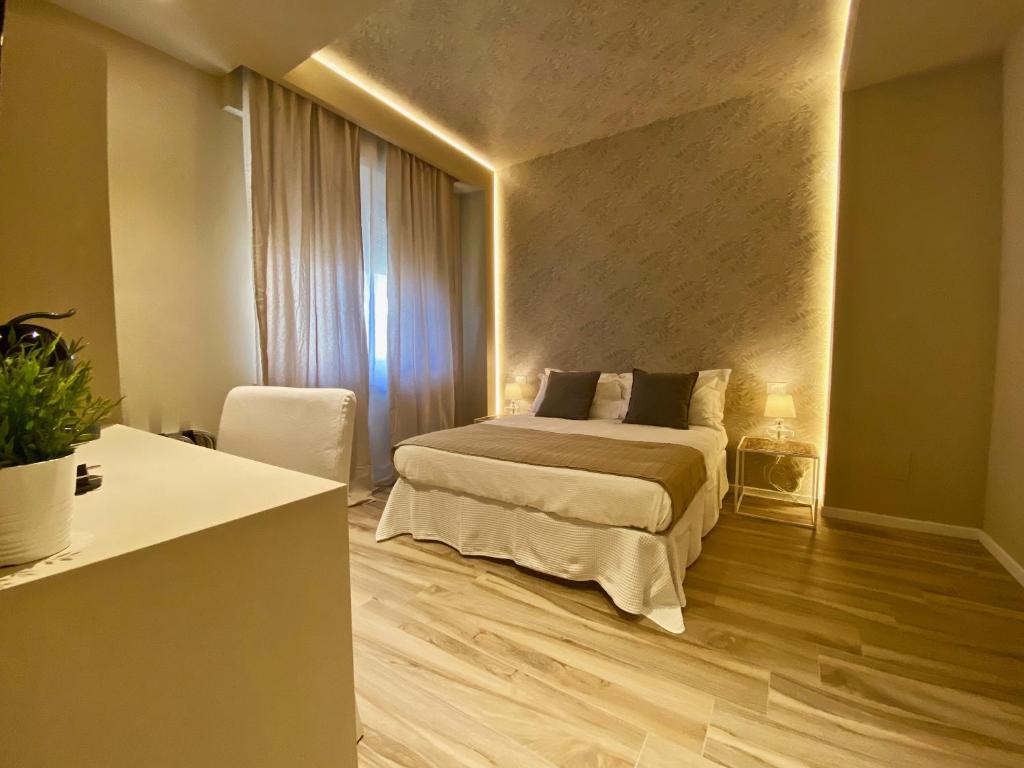 a bedroom with a bed and a table and a window at Harmony House Prestige in Pisa