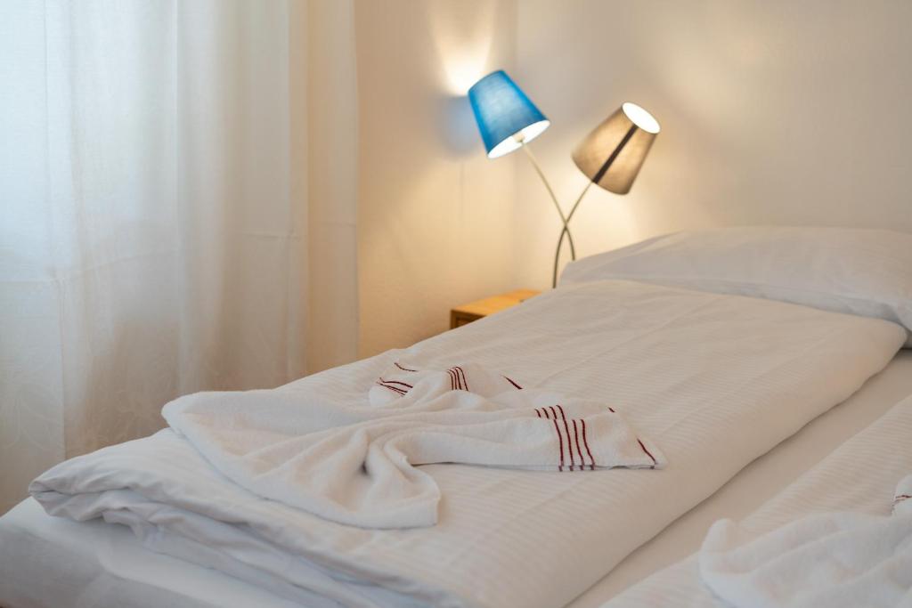un accappatoio bianco posto sopra un letto di Between Lakes Apartments - 54 a Interlaken