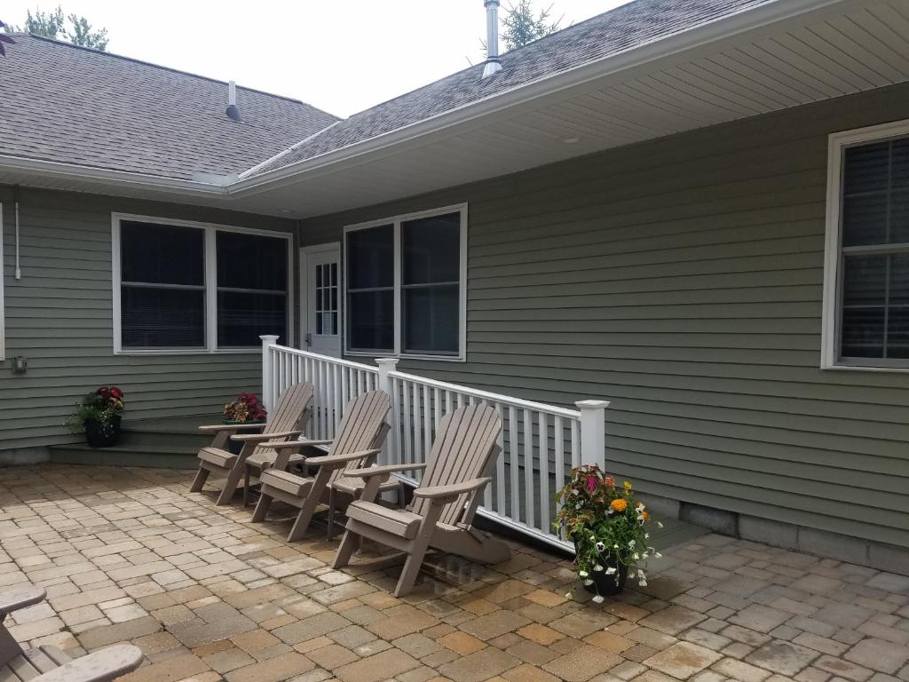 a group of chairs on a porch of a house at The Lakehouse Inn Geneva in Geneva-on-the-Lake