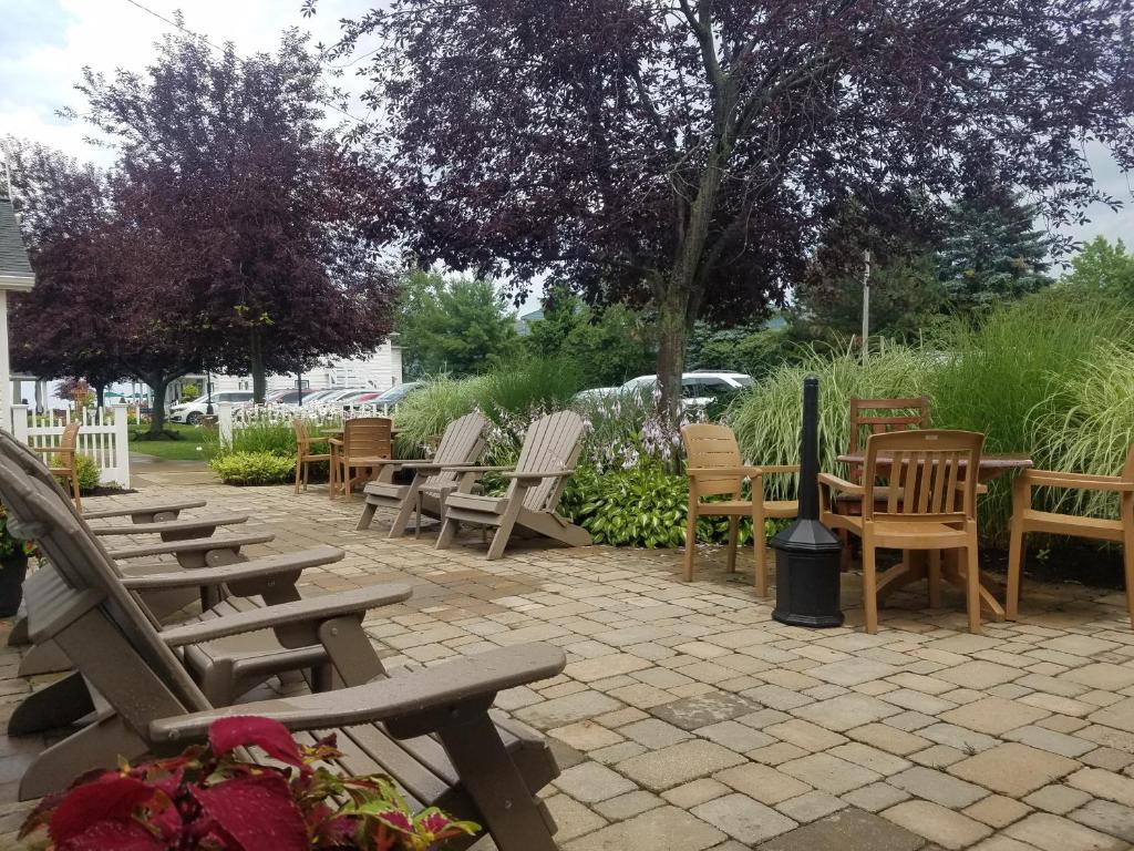 a group of chairs and tables and chairs on a patio at The Lakehouse Inn Geneva in Geneva-on-the-Lake