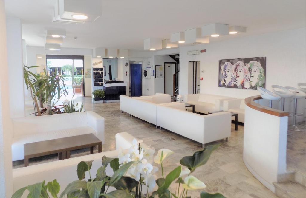 salon z białymi meblami i roślinami w obiekcie Hotel Diplomatic w mieście Riccione