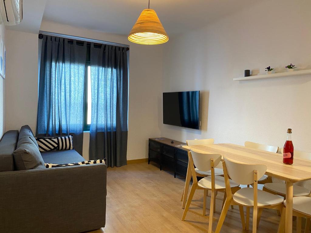 een woonkamer met een tafel en een bank bij Apartments Sant Lluis CENTER, 2 min walk from the sea in Lloret de Mar