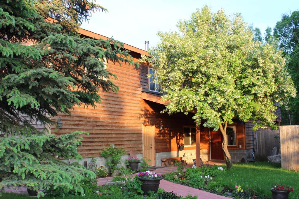 una casa de madera con un árbol en el patio en Maria's Creekside B&B en Anchorage