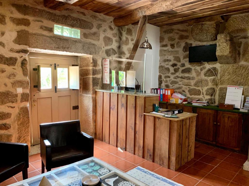 een woonkamer met een tafel en een tv in een gebouw bij Casa Grande do Seixo in Vidago