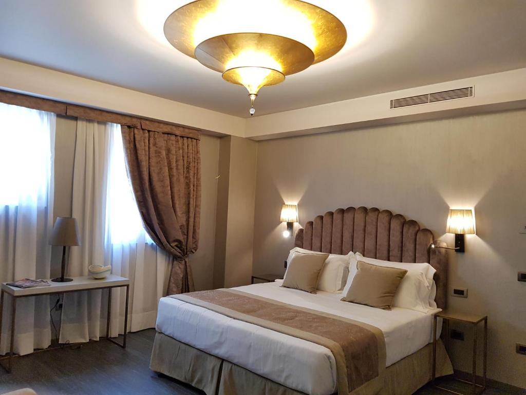 a bedroom with a large bed and a chandelier at Hotel Aquarius Venice - Ascend Collection in Venice