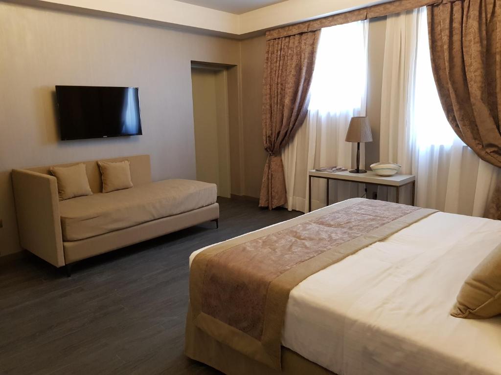 a hotel room with a bed and a couch at Hotel Aquarius Venice - Ascend Collection in Venice