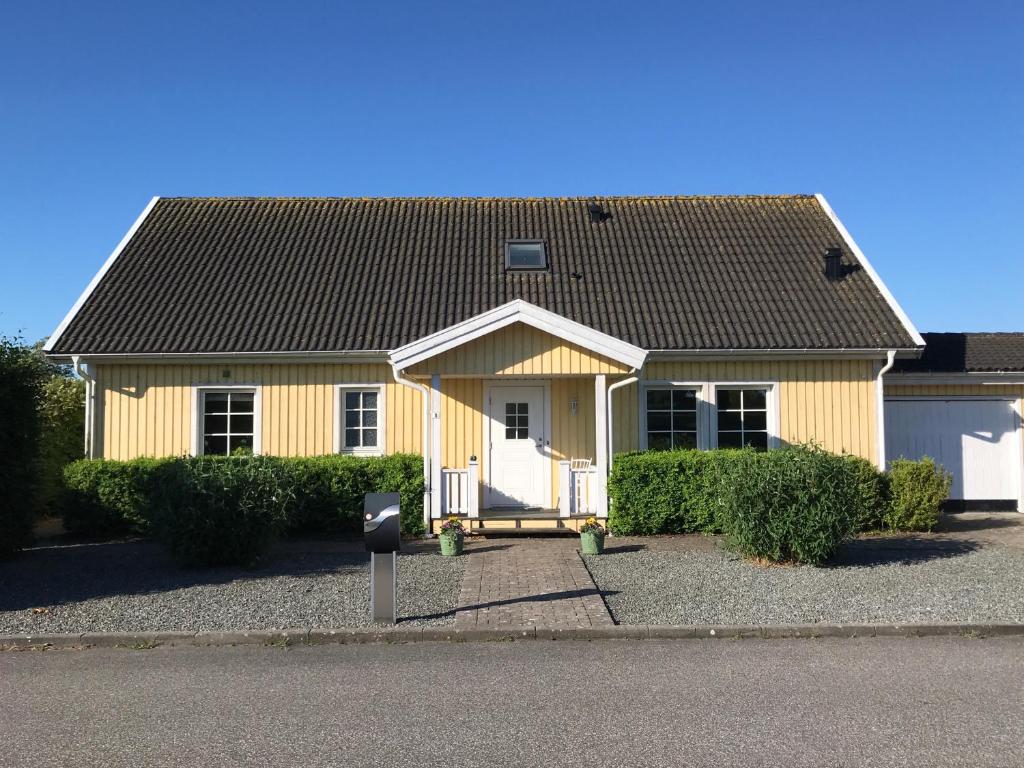 ein gelbes Haus mit Parkuhr davor in der Unterkunft Anettes Bed & Breakfast Falster in Eskilstrup