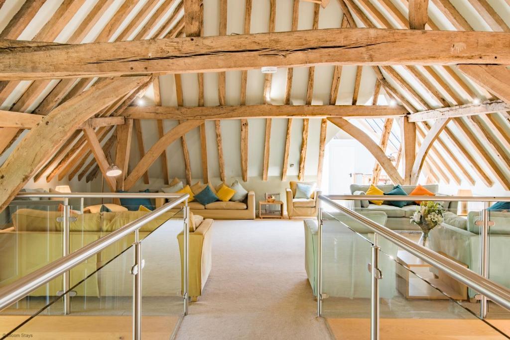 カンタベリーにあるGreat Higham Barn Complex by Bloom Staysの木製の天井と階段のある広い客室です。