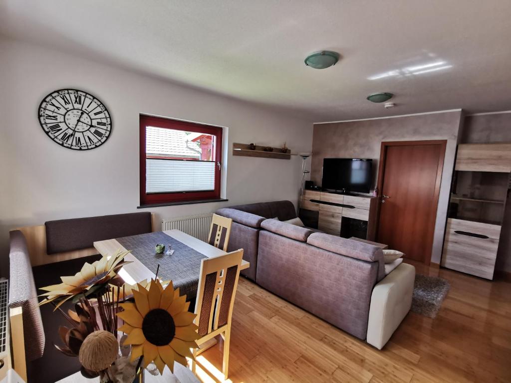 ein Wohnzimmer mit einem Tisch und einem Sofa in der Unterkunft Apartma NEVA in Bohinj