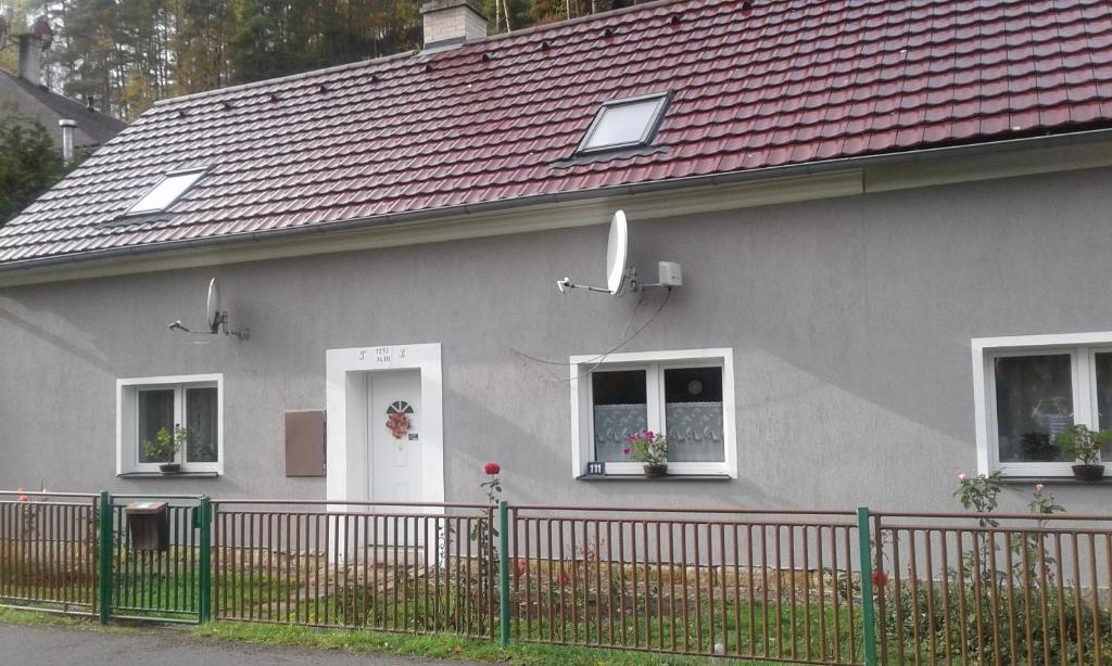 una casa gris con techo rojo y valla en České Švýcarsko - Apartmán pro 2-3 dospělé osoby, en Srbská Kamenice