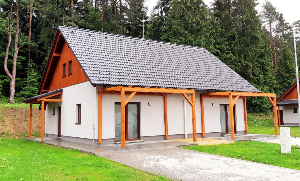 Apartmány Deluxe في Sázava: مبنى برتقالي وبيض بسقف أسود