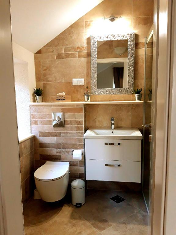 W łazience znajduje się toaleta, umywalka i lustro. w obiekcie Old Town Sea Front M&M Apartment Korčula w Korčuli