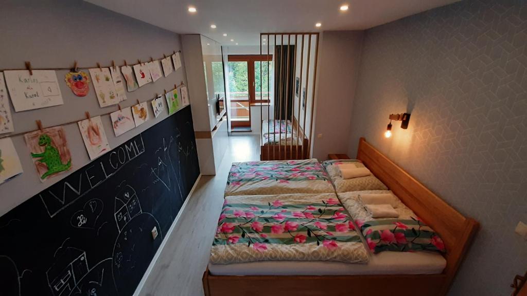 1 dormitorio con cama y pared de pizarra en Apartmán Tatran A 12, en Donovaly