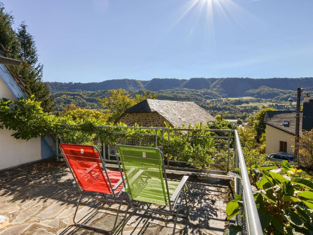 3 Stühle auf einem Balkon mit Aussicht in der Unterkunft Beautiful villa 150 m from the beach in Vic-sur-Cère