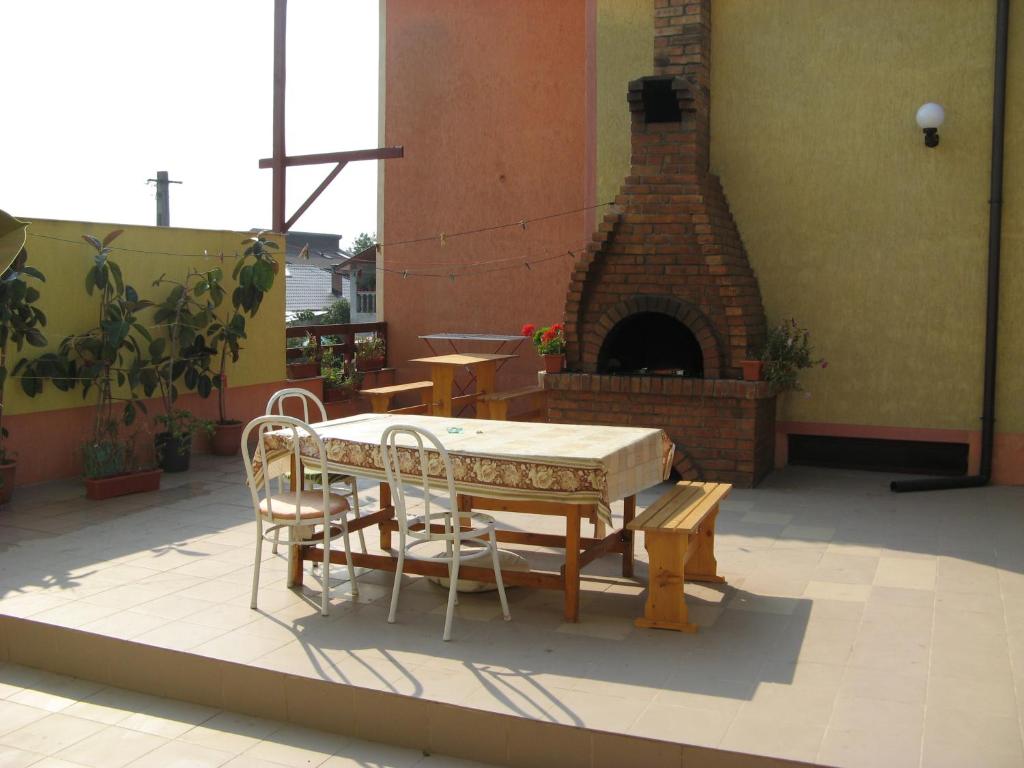 - une table et des chaises sur une terrasse avec un four en briques dans l'établissement Vila GABY Mangalia, à Mangalia