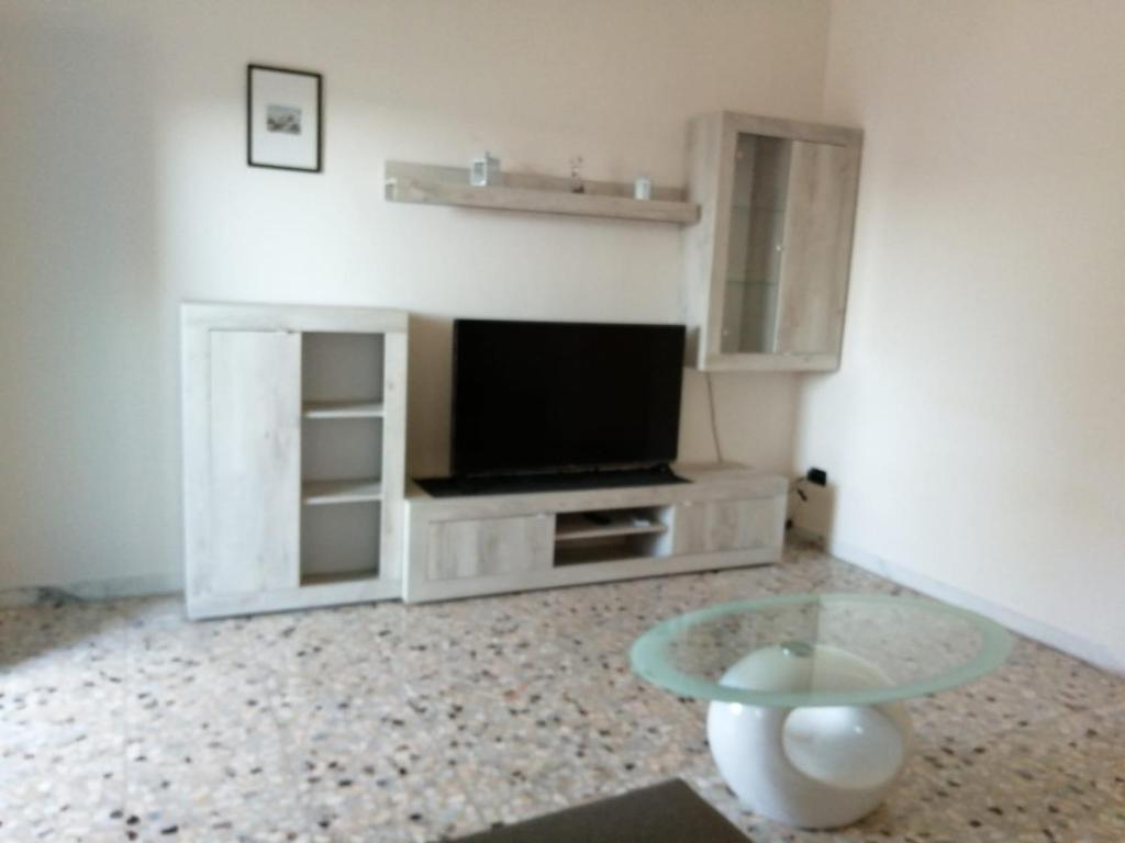 uma sala de estar com uma televisão e uma mesa de vidro em Montedarena SILVER - A due passi dal mare em Pulsano