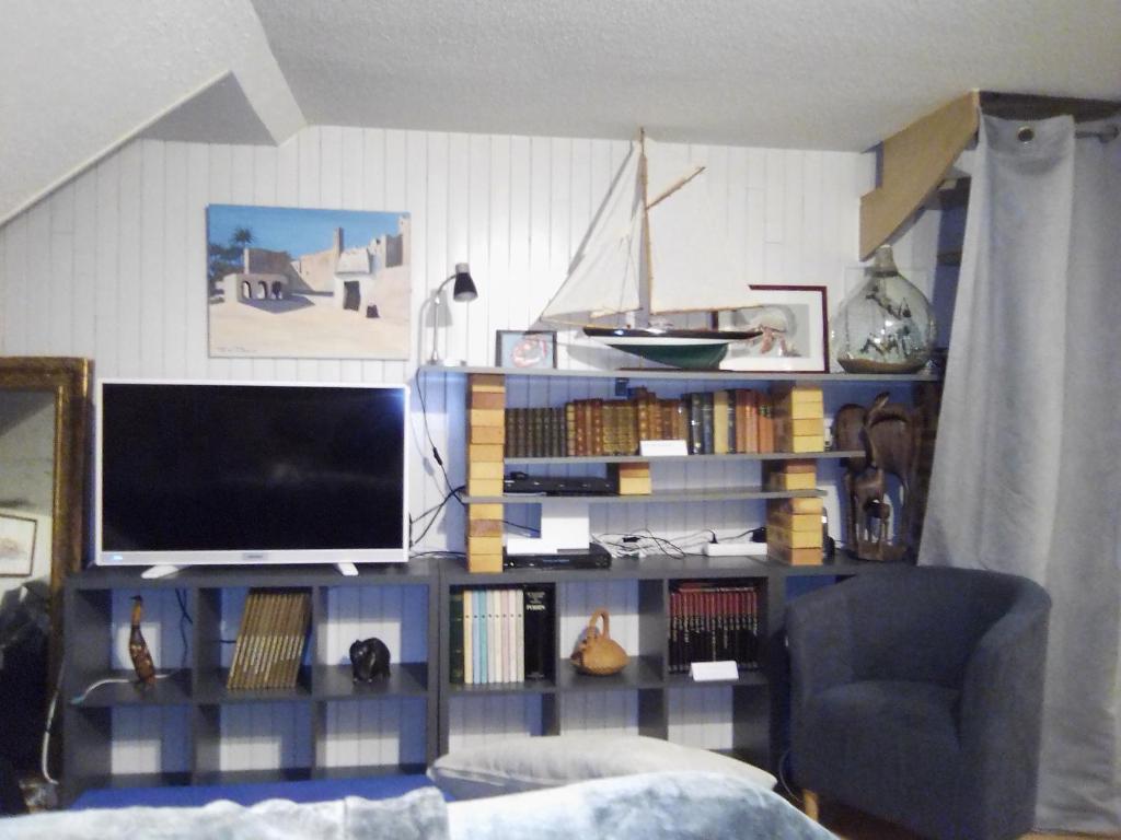 - un salon avec une télévision sur une étagère dans l'établissement ART APPART KEMPER, à Quimper
