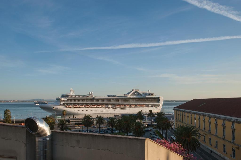 a cruise ship is docked in a harbor at Light Green Apartments - Downtown Lisbon in Lisbon