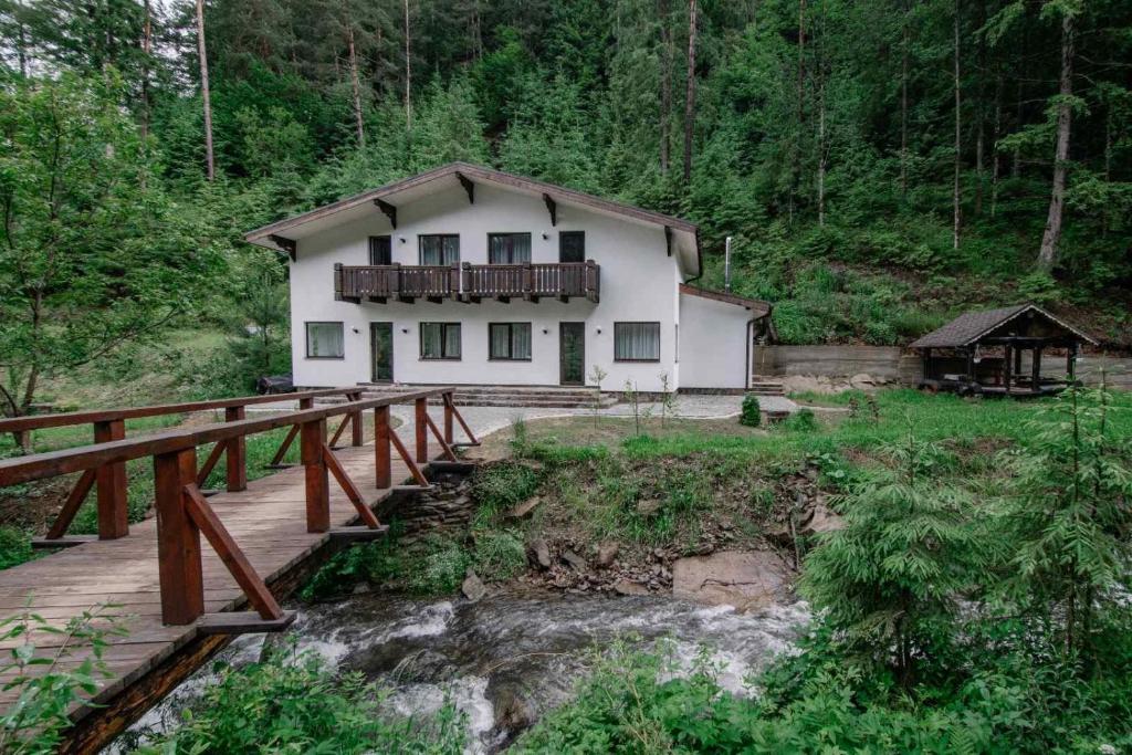 ein Haus auf einer Holzbrücke im Wald in der Unterkunft Котедж in Mischhirja