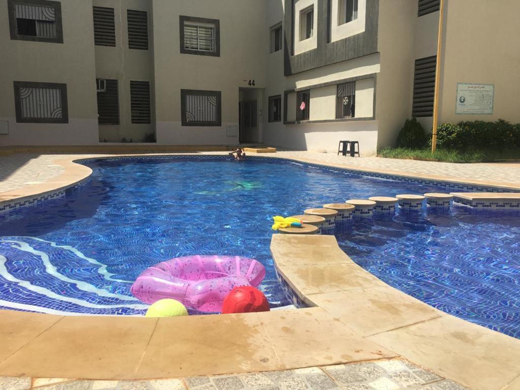 a large swimming pool with a toy in the water at Agréable Appartement avec piscine in Saïdia
