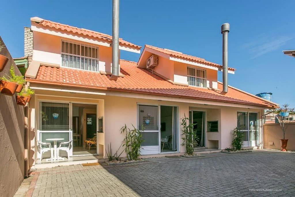 una casa con techo naranja y entrada en Modernos chalés a 90 metros da praia, en Florianópolis