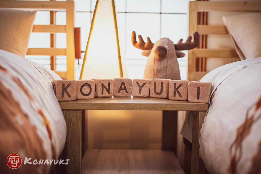 a moose standing behind a sign that reads konymush at KONAYUKI in Myoko