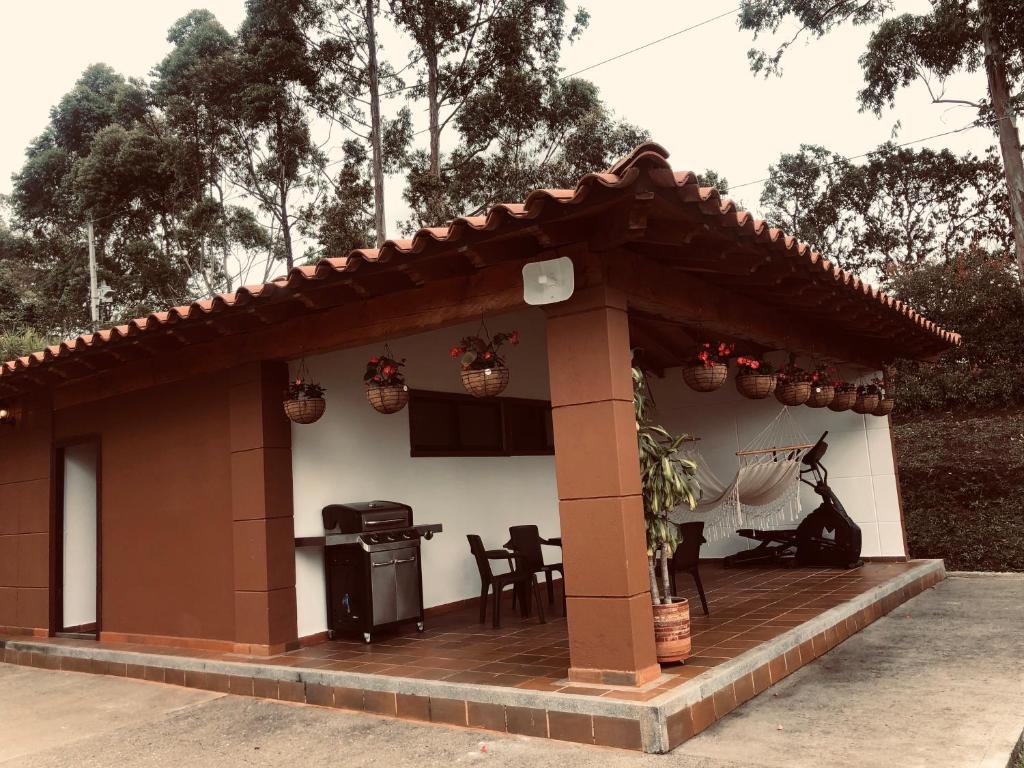 ein Haus mit einer Terrasse mit einem Grill und einem Tisch in der Unterkunft Cottage Refuge in Rionegro
