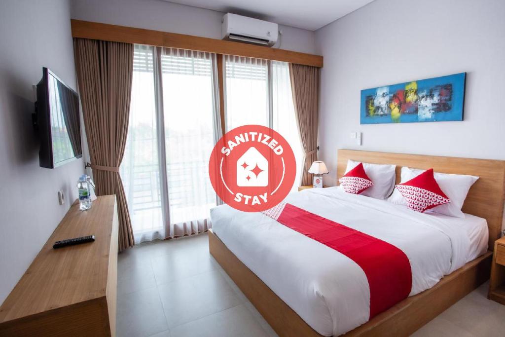 a hotel room with a bed with a red sign on it at OYO 1207 Pondok 789 Near Canggu Echo beach in Canggu