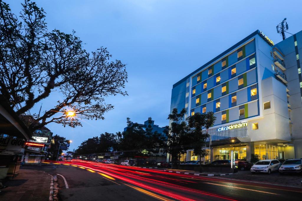 a city street with cars driving past a building at Hotel Citradream Bandung in Bandung