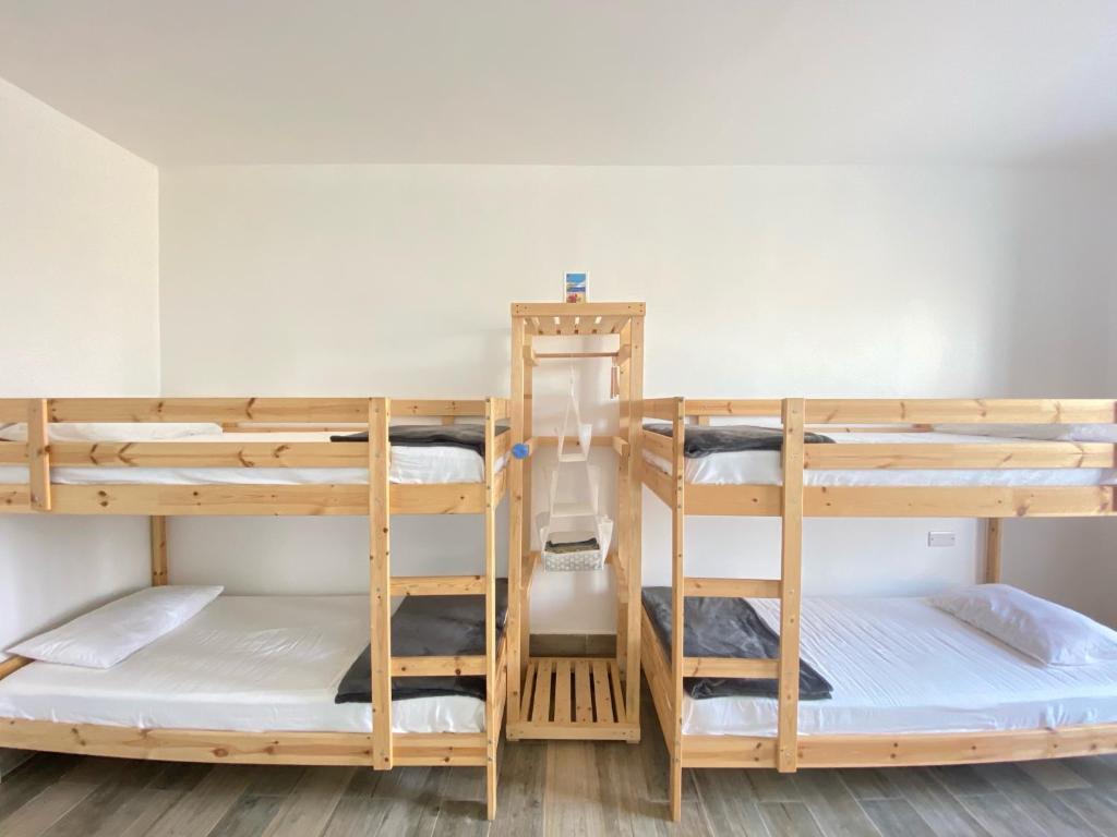 a room with three bunk beds in a dorm room at Ash Villa in Al Ashkharah