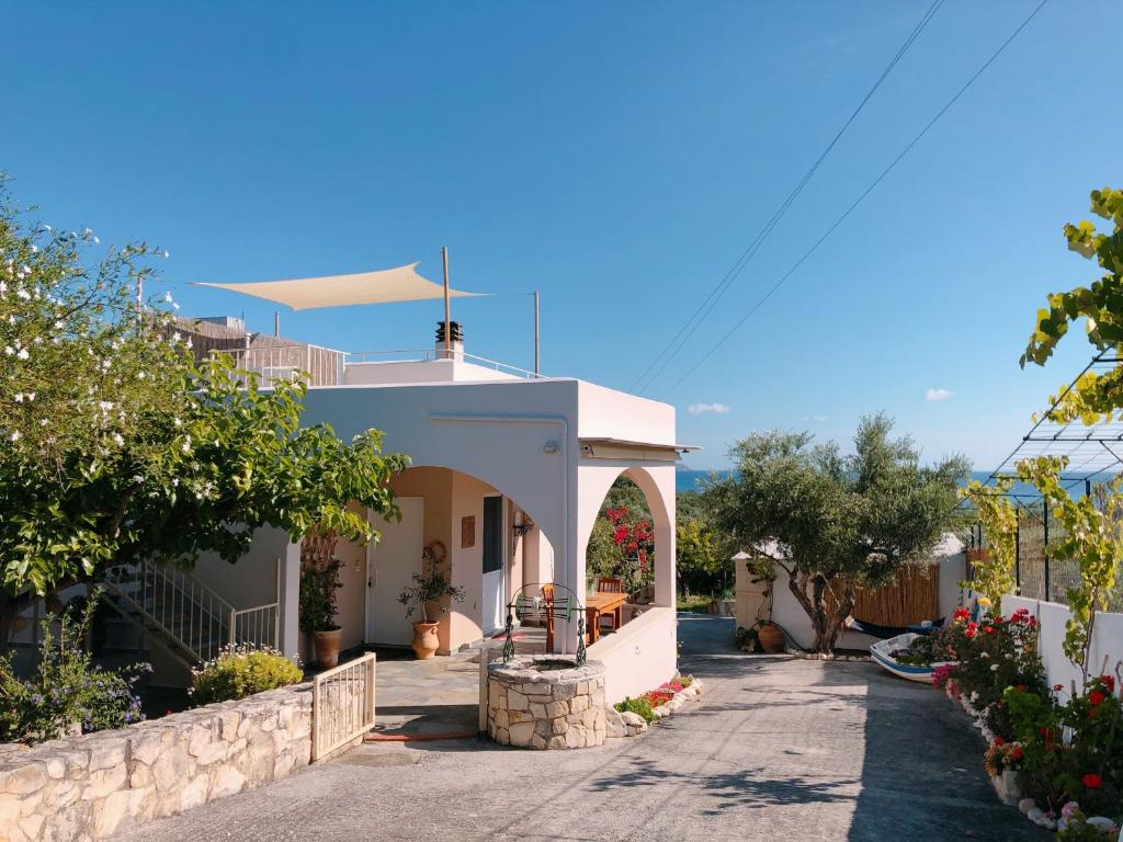 una casa blanca con un arco en un patio en Elia's House Traditional & Cozy, en Kalyves