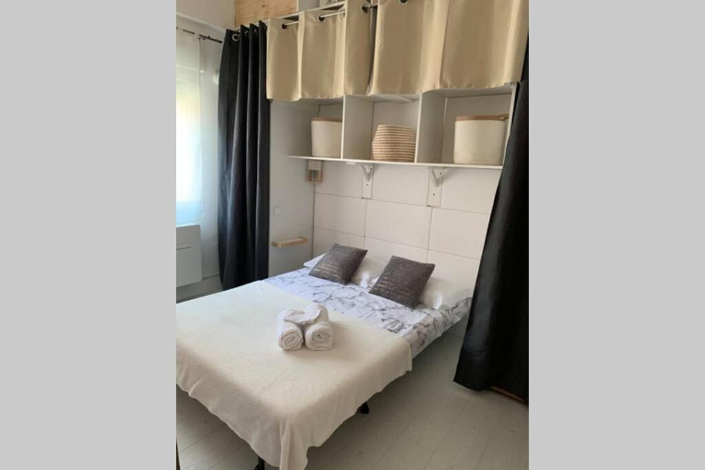 Un dormitorio con una cama con dos zapatos blancos. en Charmant petit studio en centre ville, en Bastia