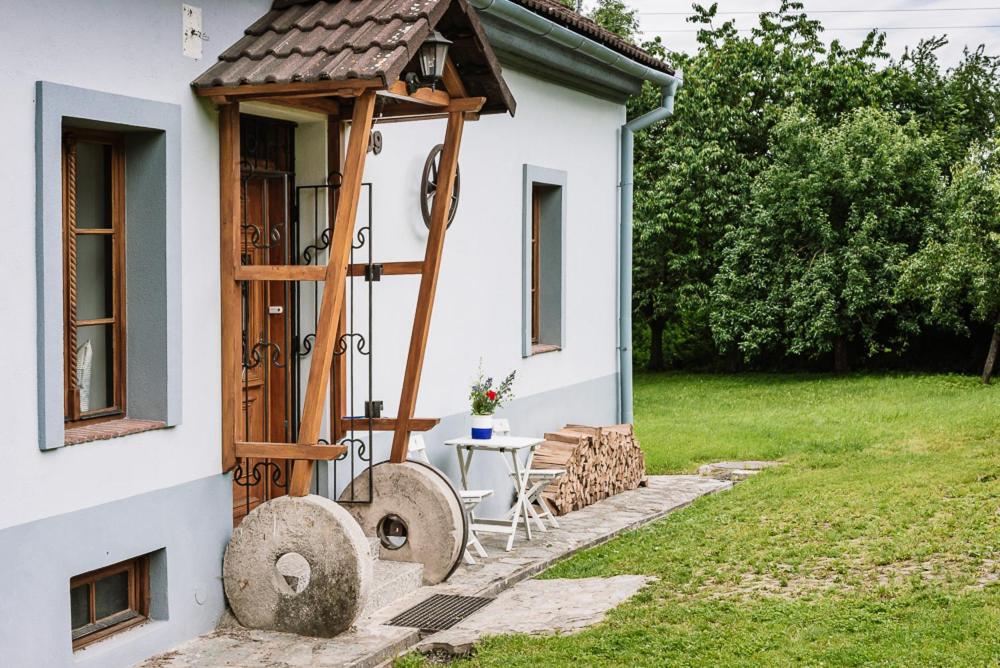 een klein wit huis met een tafel en een vogelhuisje bij Černohorka in Černá Hora
