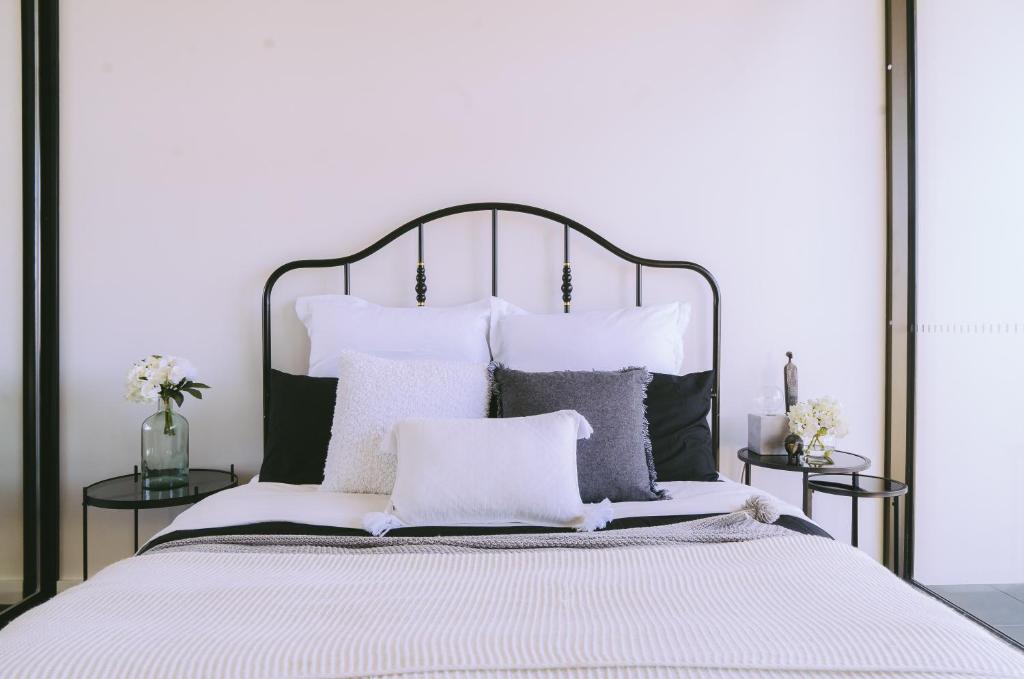 a bedroom with a large white bed with pillows at Capitol Executive Apartment on London Circuit in Canberra