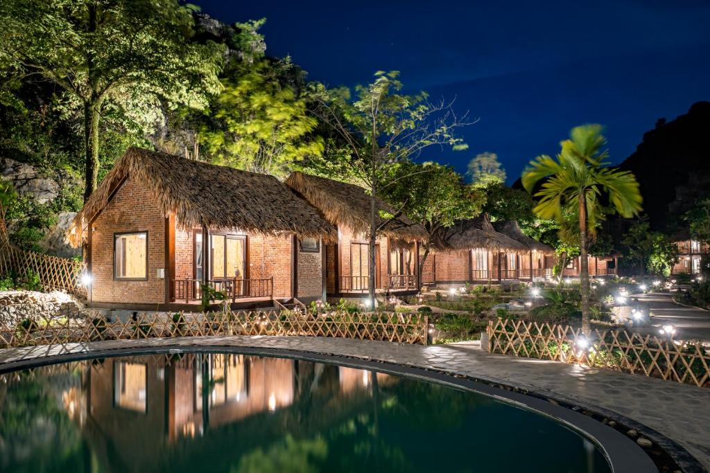 a resort with a swimming pool at night at Mường Village Ninh Bình in Ninh Binh