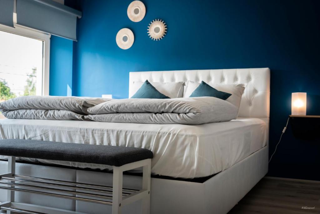 a bedroom with blue walls and a white bed with a chair at Mines de Ryen in La Bruyère