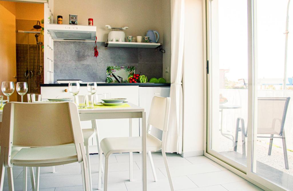 a kitchen with a white table and chairs in a room at La casa di pasqui in SantʼAntonio Abate