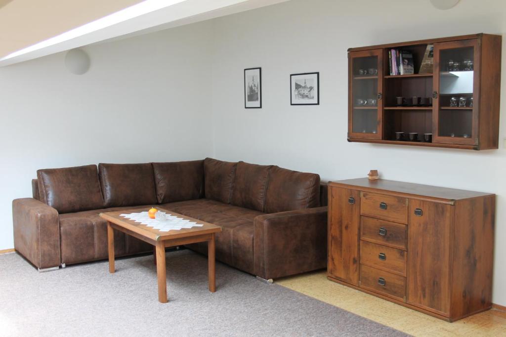 a living room with a brown couch and a table at Ubytovanie v súkromí Nová Baňa in Nová Baňa