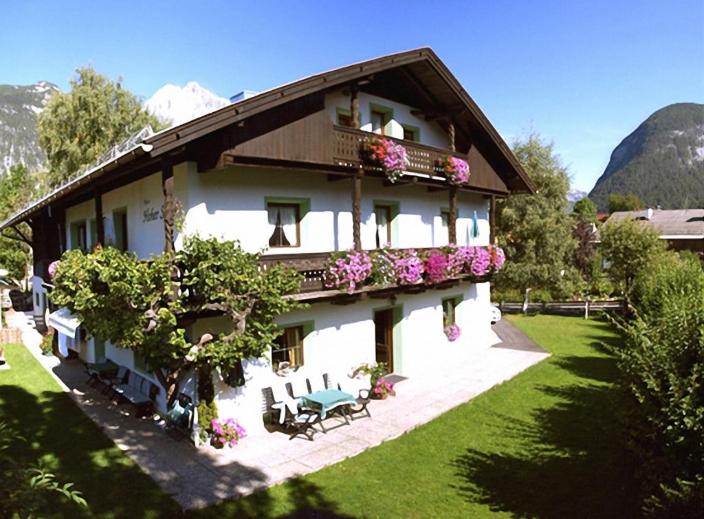 un edificio con flores a un lado. en Haus Hoher Sattel, en Leutasch